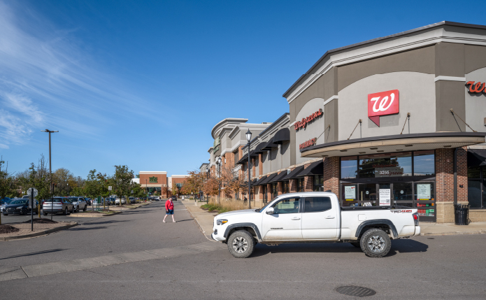 White truck passing Walgreens into parking lot.