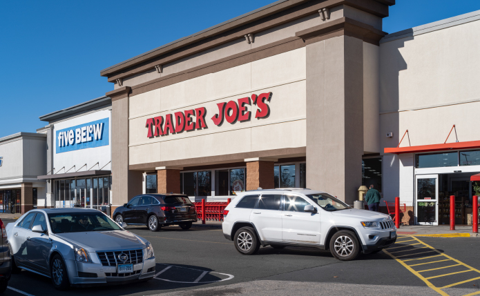 Busy lot with cars pulled up in front of Trader Joe's.