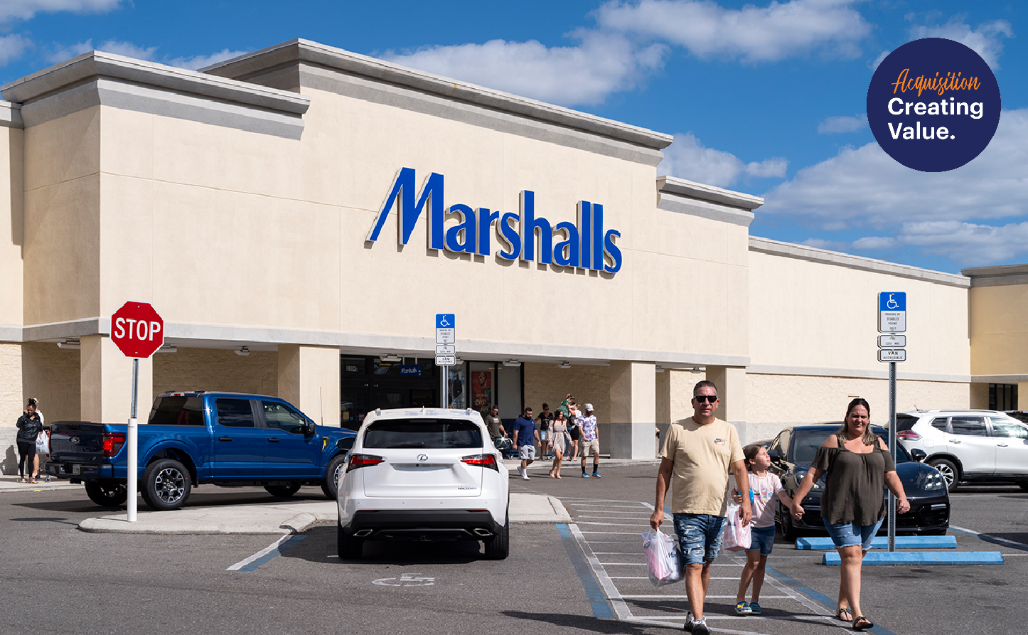 Family exiting Marshalls into parking lot.