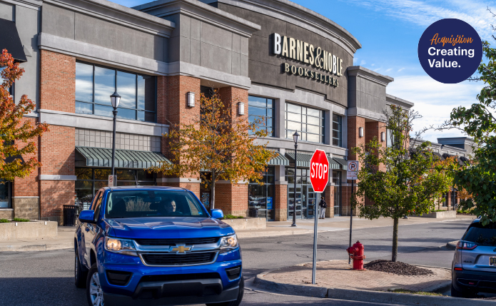 Blue SUV turning into a parking lot in front of Barnes & Noble.