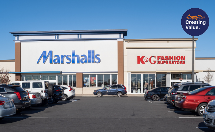 Marshalls and K&G Fashion with aisle of parked cars in front.