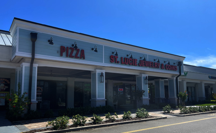 Pizza and Jewelry storefront with planters in front.