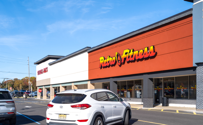 White SUV turning in parking lot of Trader Joe's and Retro Fitness.