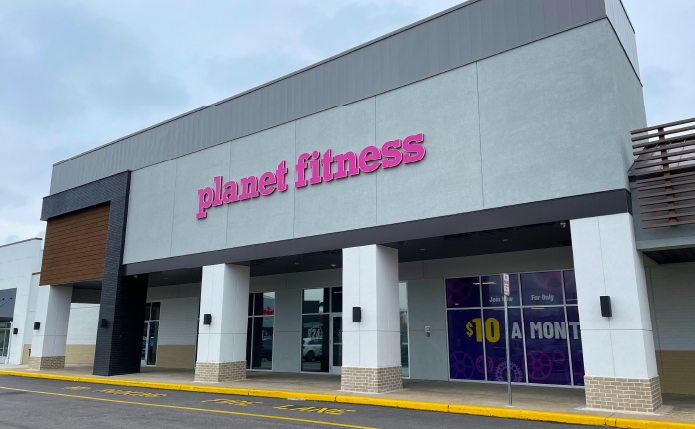 Planet Fitness storefront with grey blue sky above.