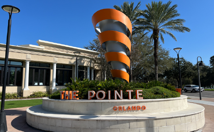 Spiral sculpture with palm trees behind it at Pointe Orlando.