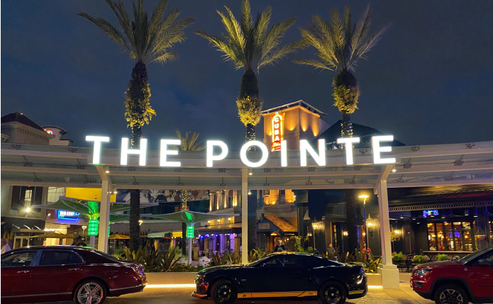 Pointe Orlando façade with valet and palm trees.