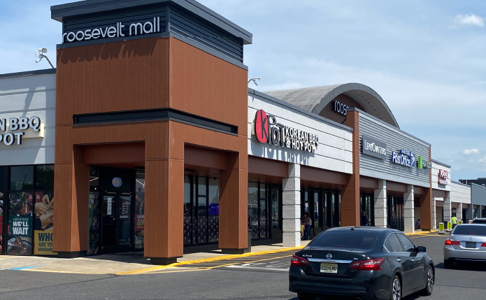 Cars passing small shops at Roosevelt Mall.