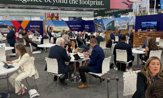 Many people around round white tables at the Brixmor booth