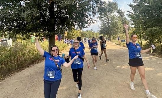 group of women in blue shirts on dirt path
