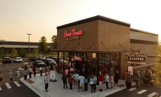 Line of people outside of Stan's Donuts at sunrise