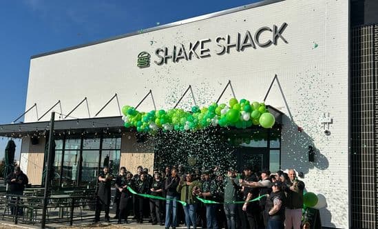 Shake Shack ribbon-cutting with green balloons and confetti outside a new storefront. Provide your feedback on BizChat