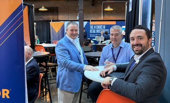 three men in a conference booth smiling