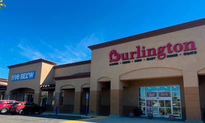 Burlington and Five Below at Vail Ranch Center in Temecula, CA, shown with warm earth‑tone architectural finishes, prominent red and blue signage, wide pedestrian walkways, and a partially filled parking lot beneath clear sunny skies.
