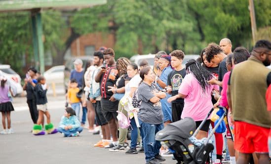 Large group of people gathers on pavement