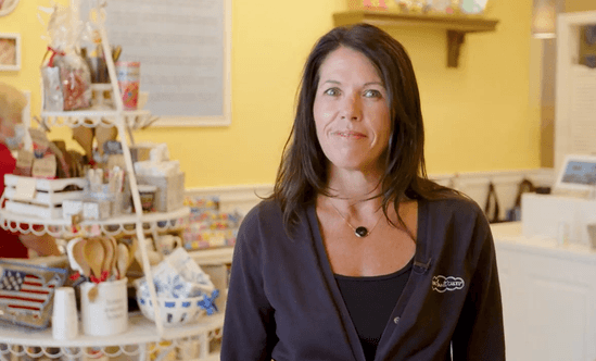 brunette woman standing in nothing bundt cakes shop with yellow walls