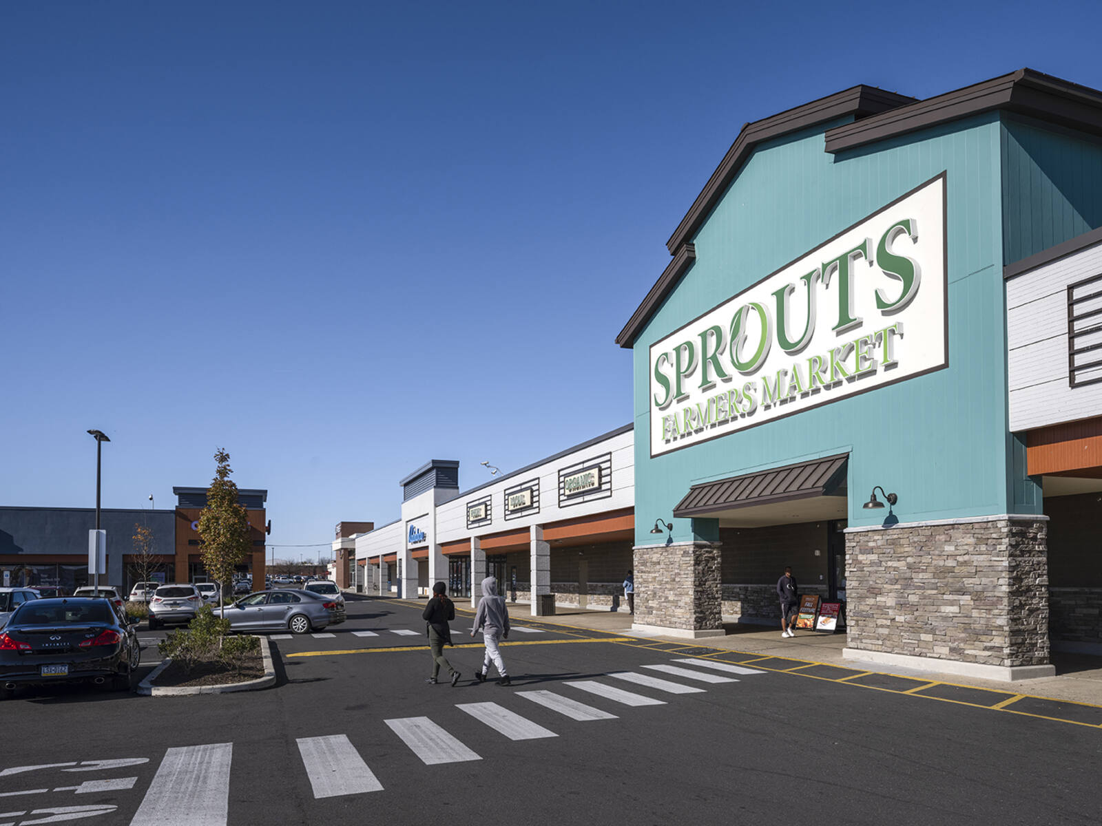 Entrance to Sprouts Farmers Market with people walking