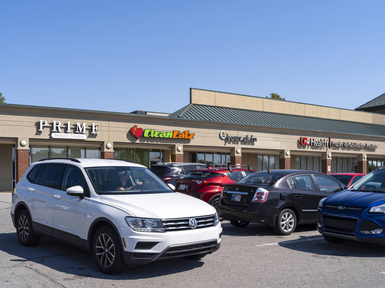 Many shops and cars at busy lot in Jeffersontown Commons.