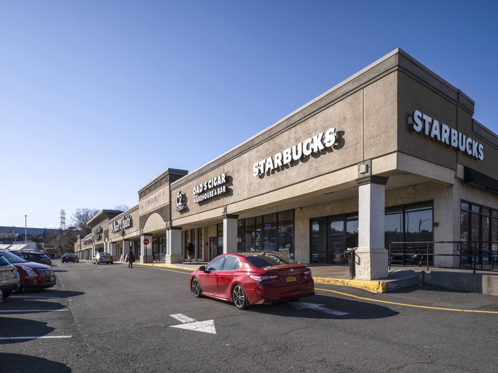 Red car passing Starbucks on access road at Rockland Plaza.