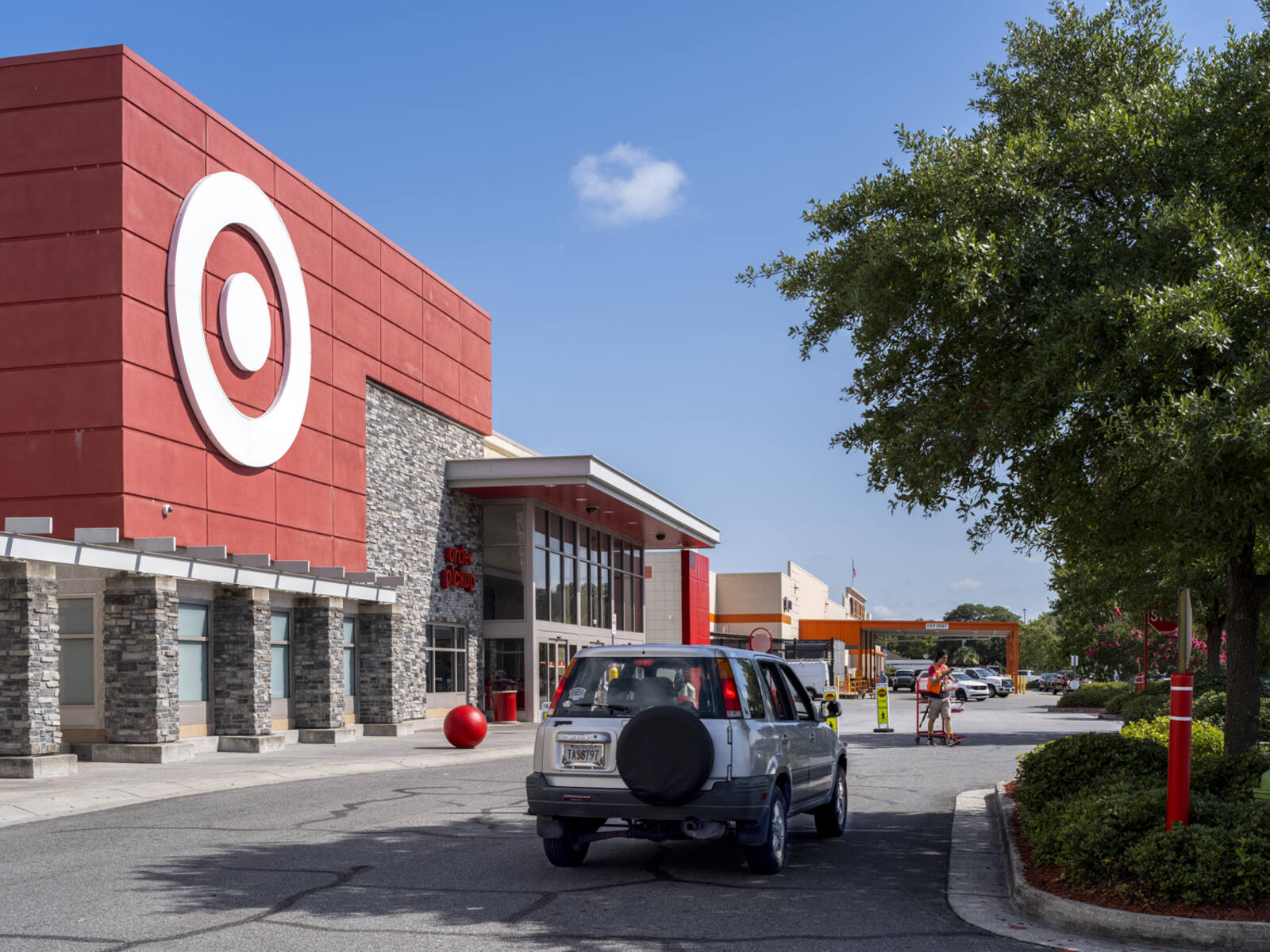 Jeep on road passing Target store with tree on the right.