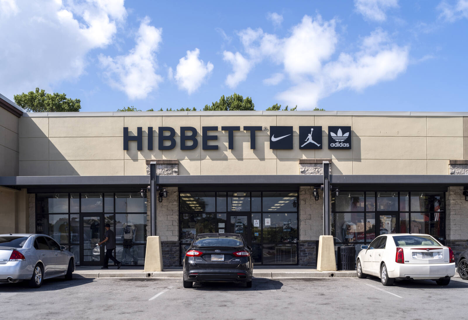 Cars parked in front of Hibbett sports store.