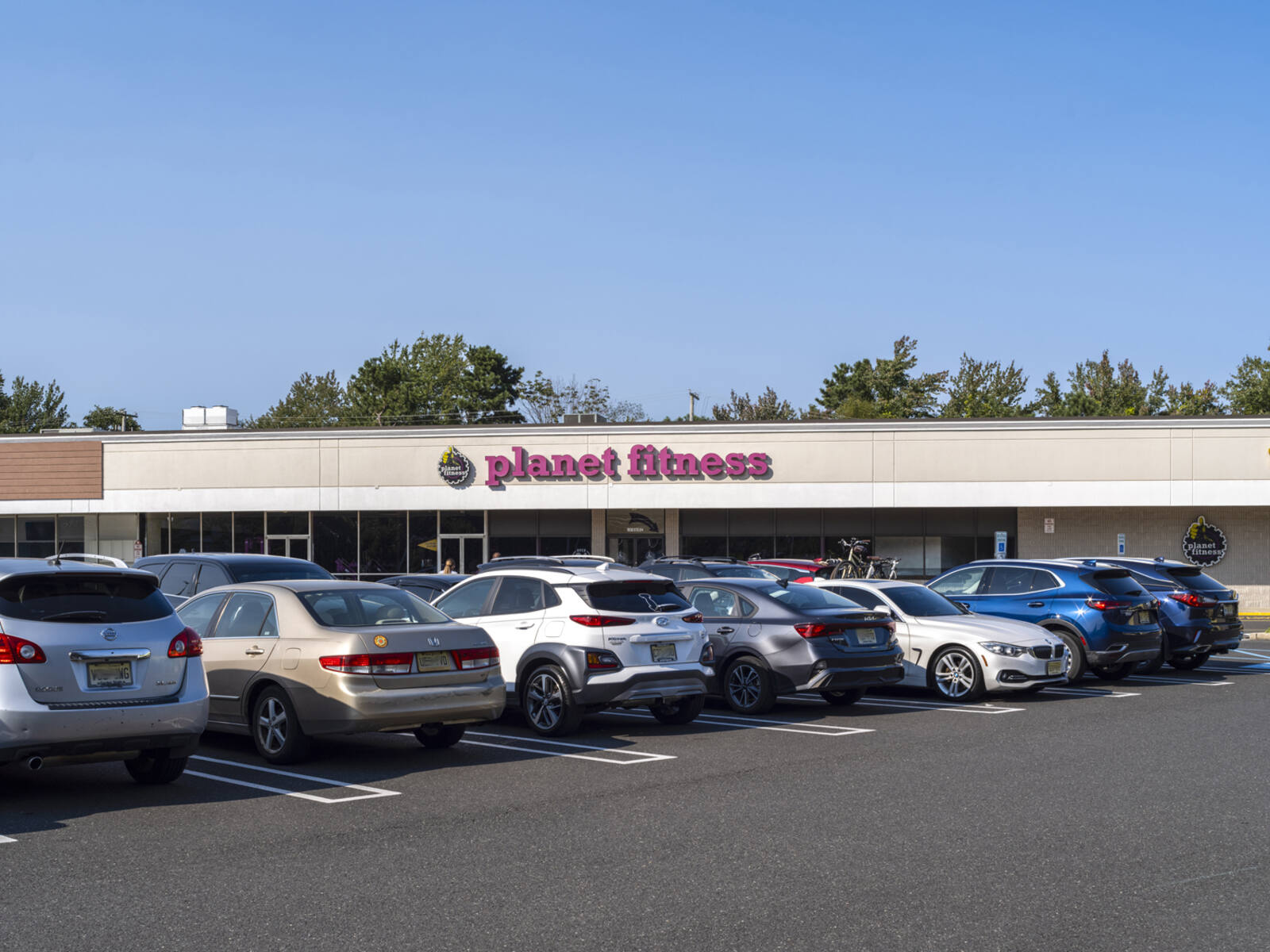 Planet Fitness with busy parking lot in front.