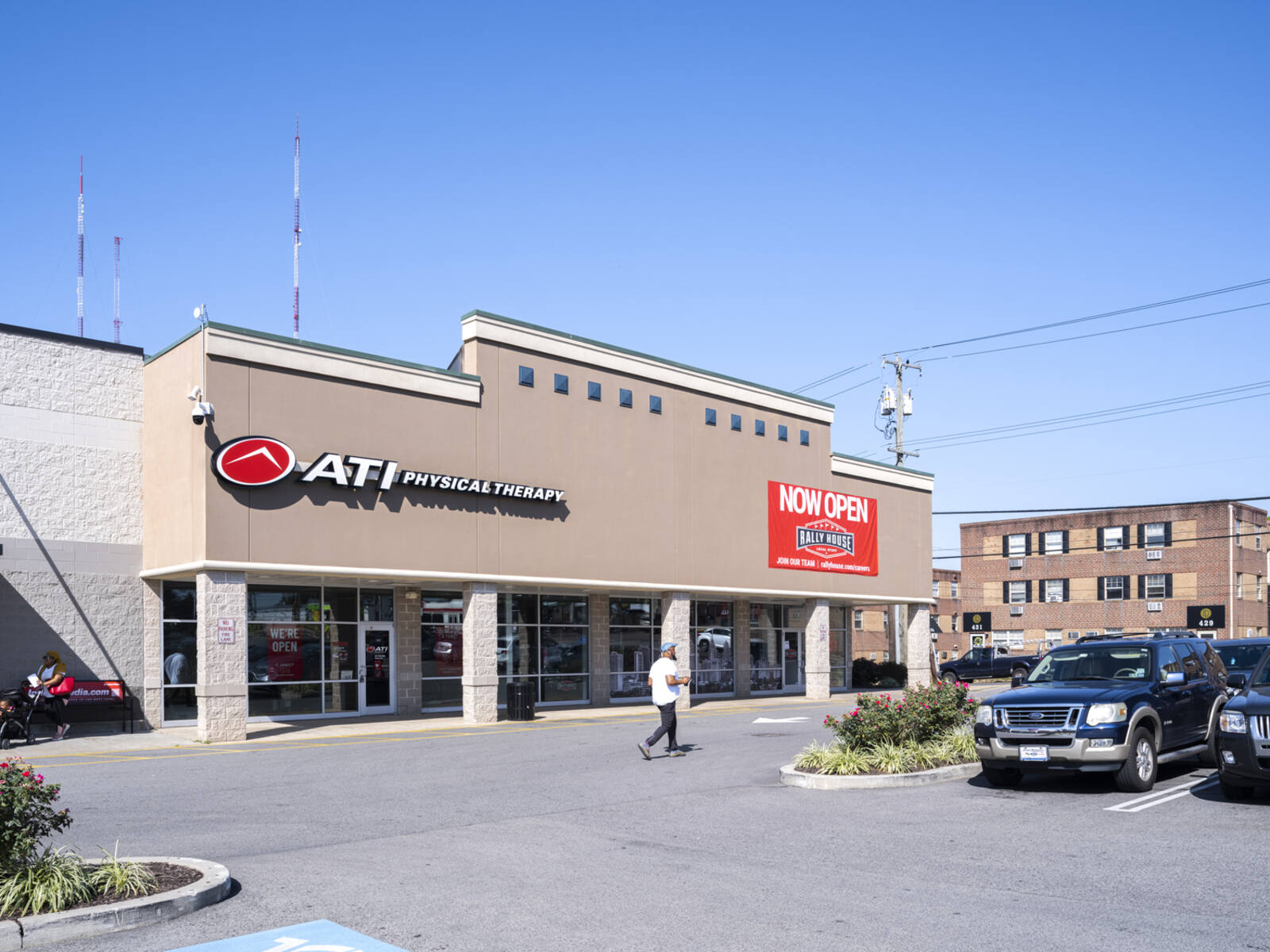 ATI Physical Therapy and parking lot with pedestrian in front.