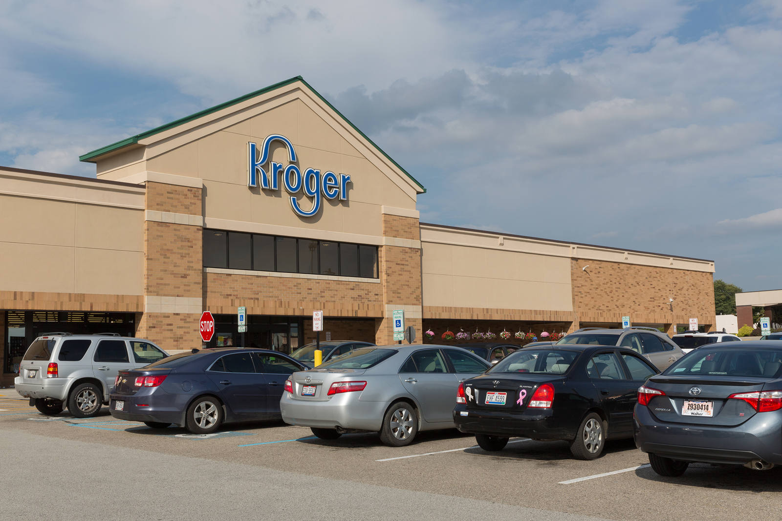 Row of parked cars in front of Kroger supermarket at Delhi Shopping Center.