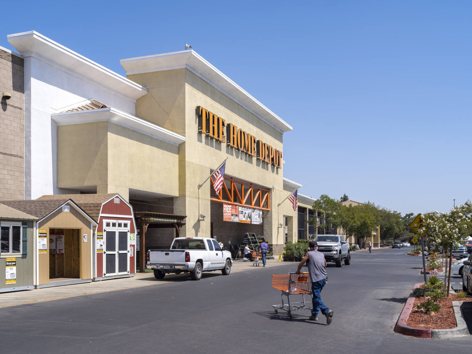 Tree-lined parking lot with customers and truck at Home Depot hardware store in Arbor Faire.
