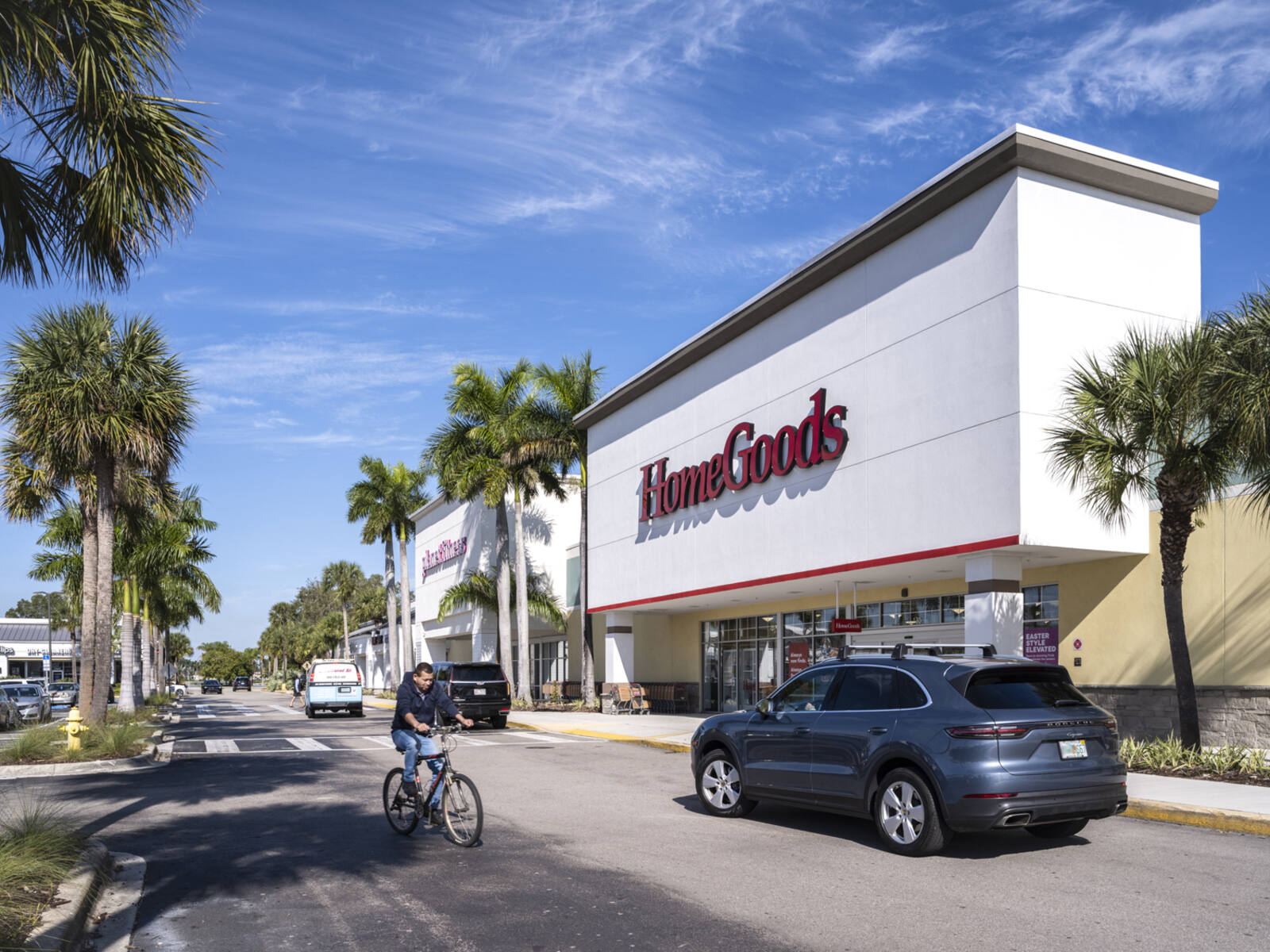 Bicyclist and SUV on access road in front of HomeGoods.