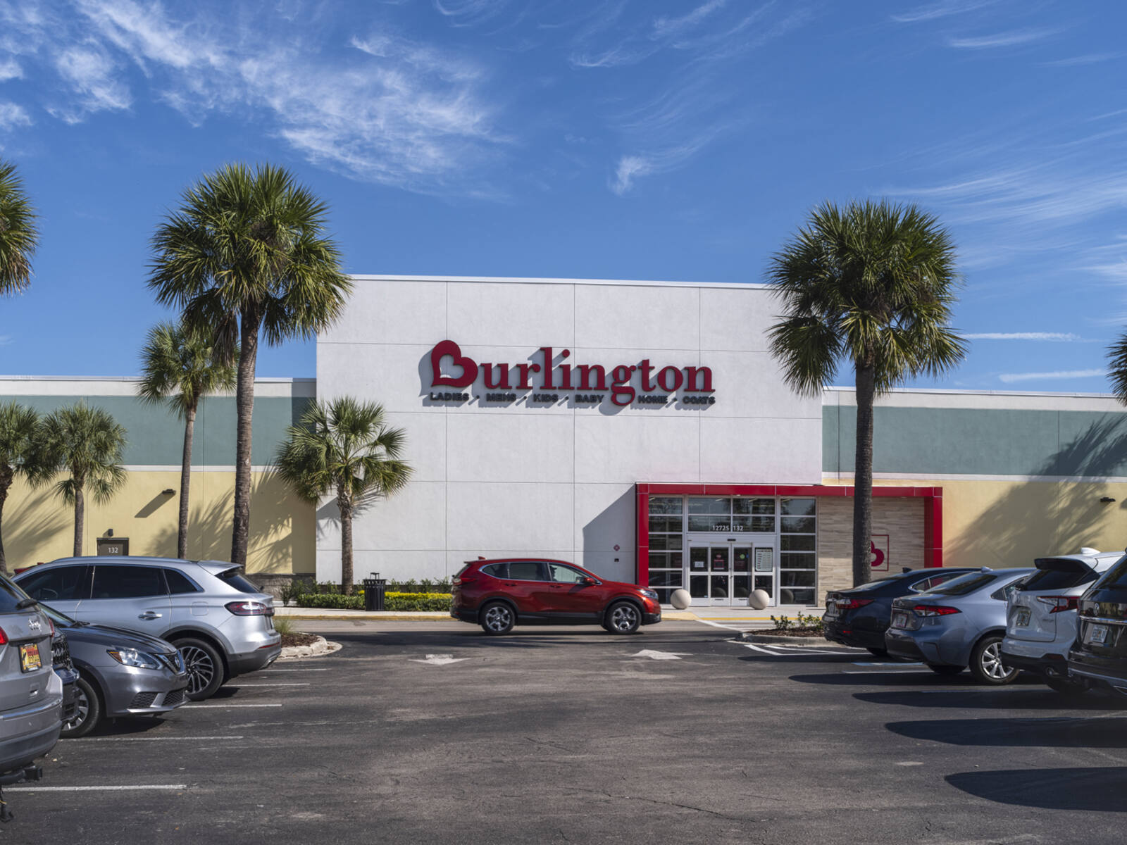 Palm trees and cars in busy lot for Burlington department store.