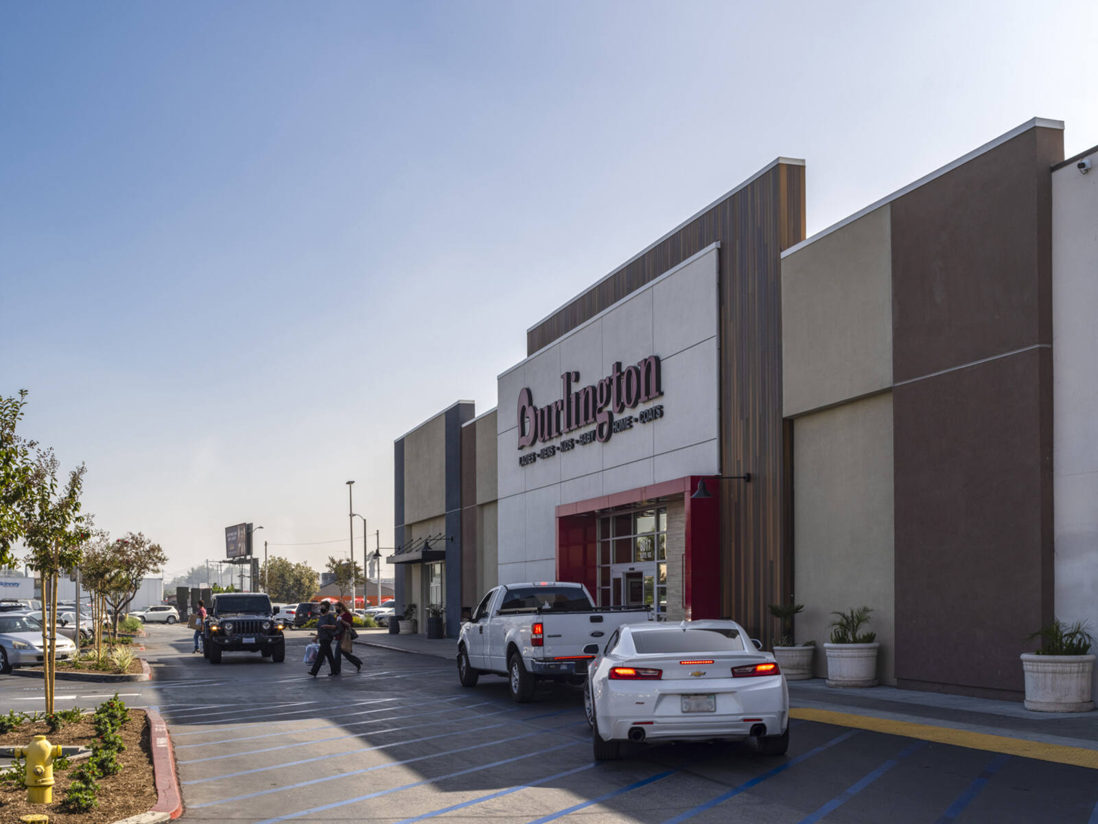 White cars pulled over in front of Burlington entrance at Cudahy Plaza.