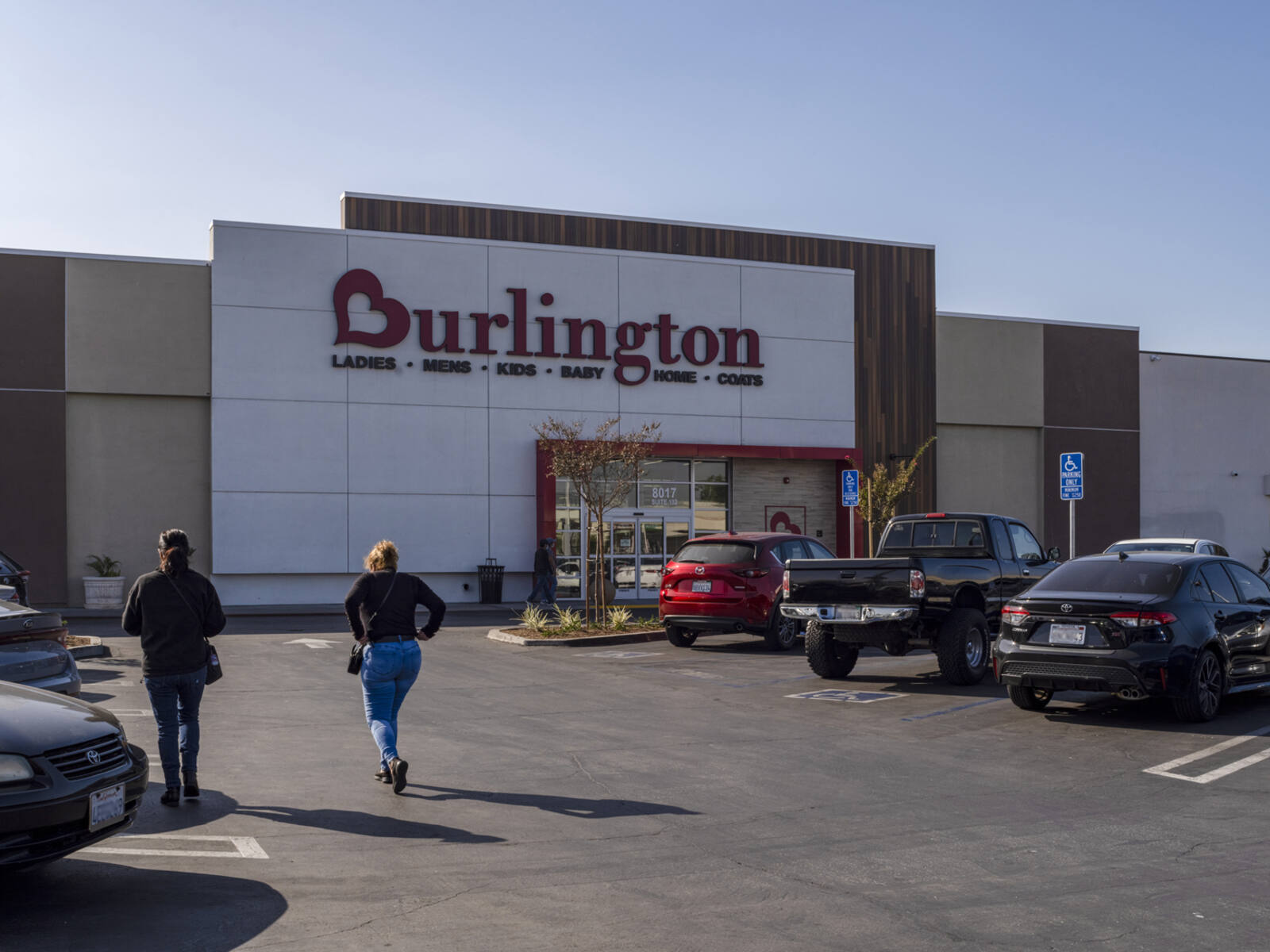 Two women walking through the parking lot towards Burlington department store at Cudahy Plaza.