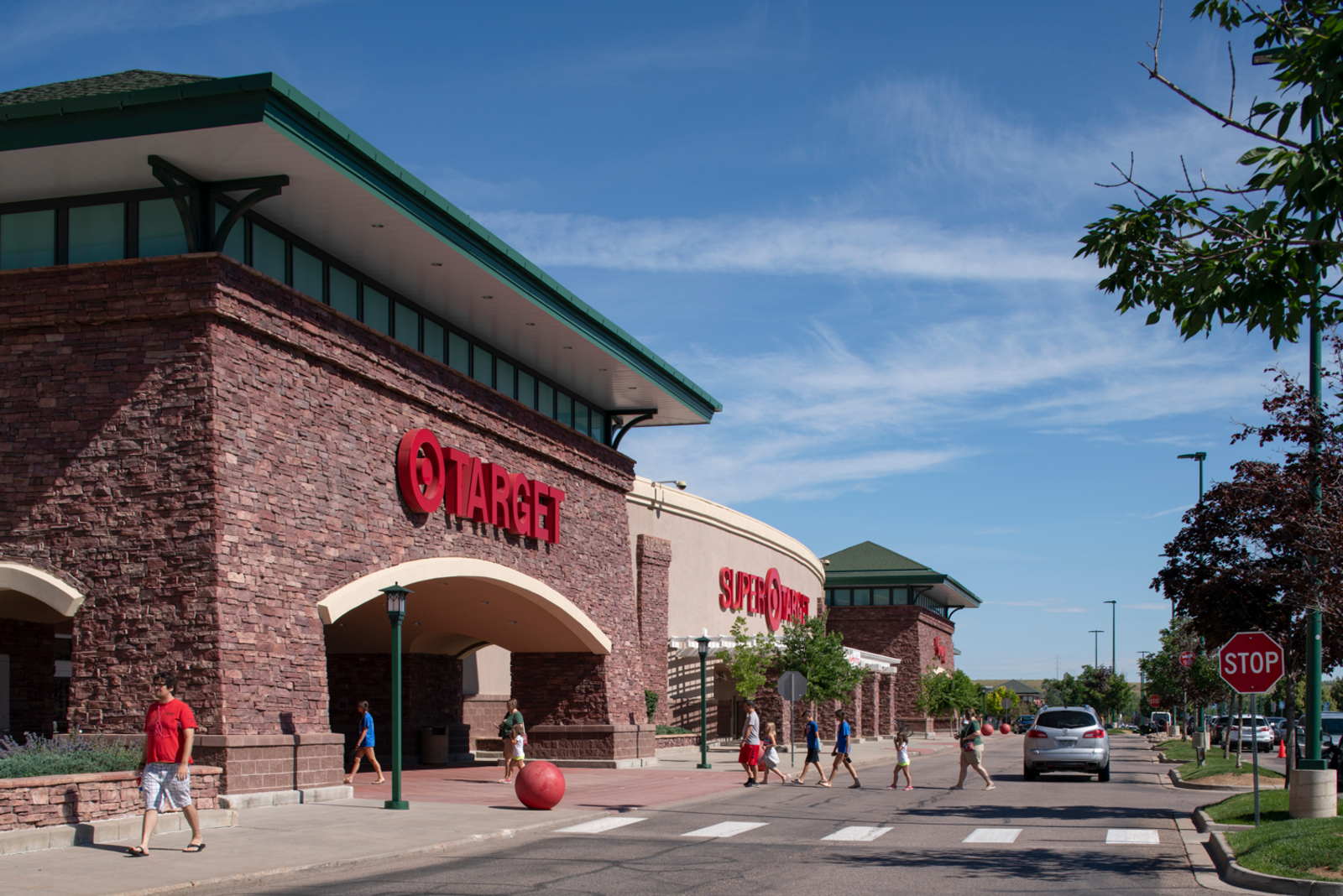 People walking throughout entrance outside of Super Target