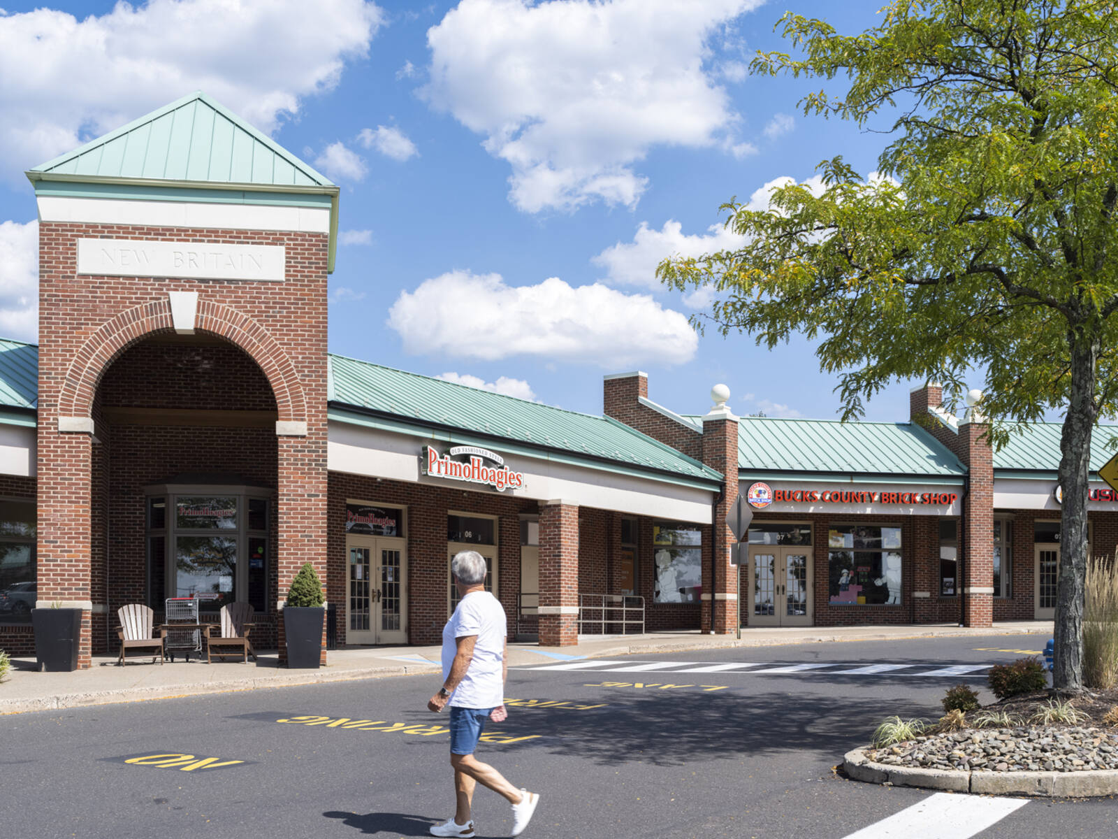 Man approaches outdoor shopping area.