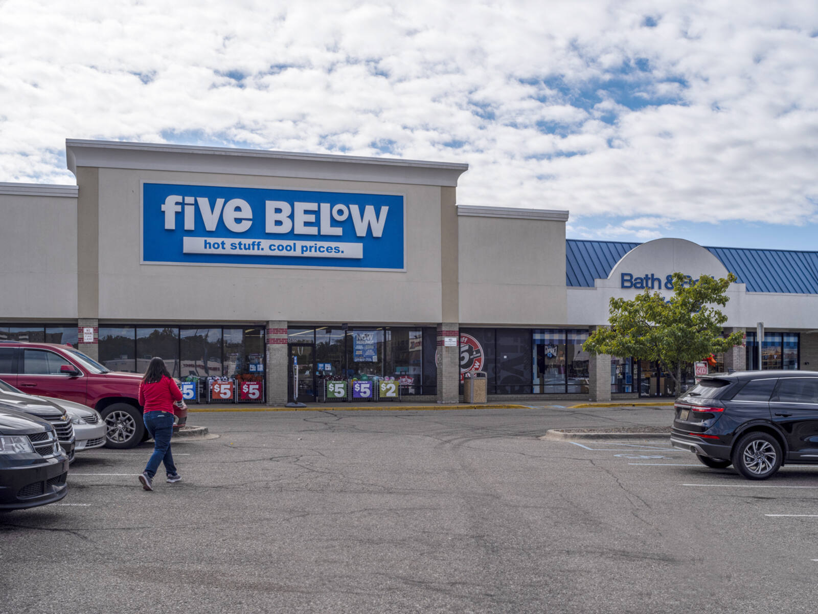 Patron approaches Five Below through aisle in parking lot.