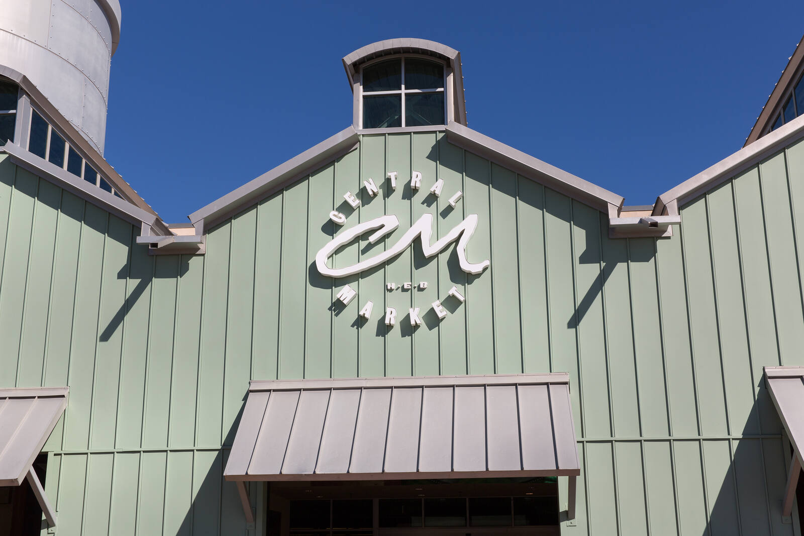 Green siding exterior of Central Market at Market Plaza shopping center