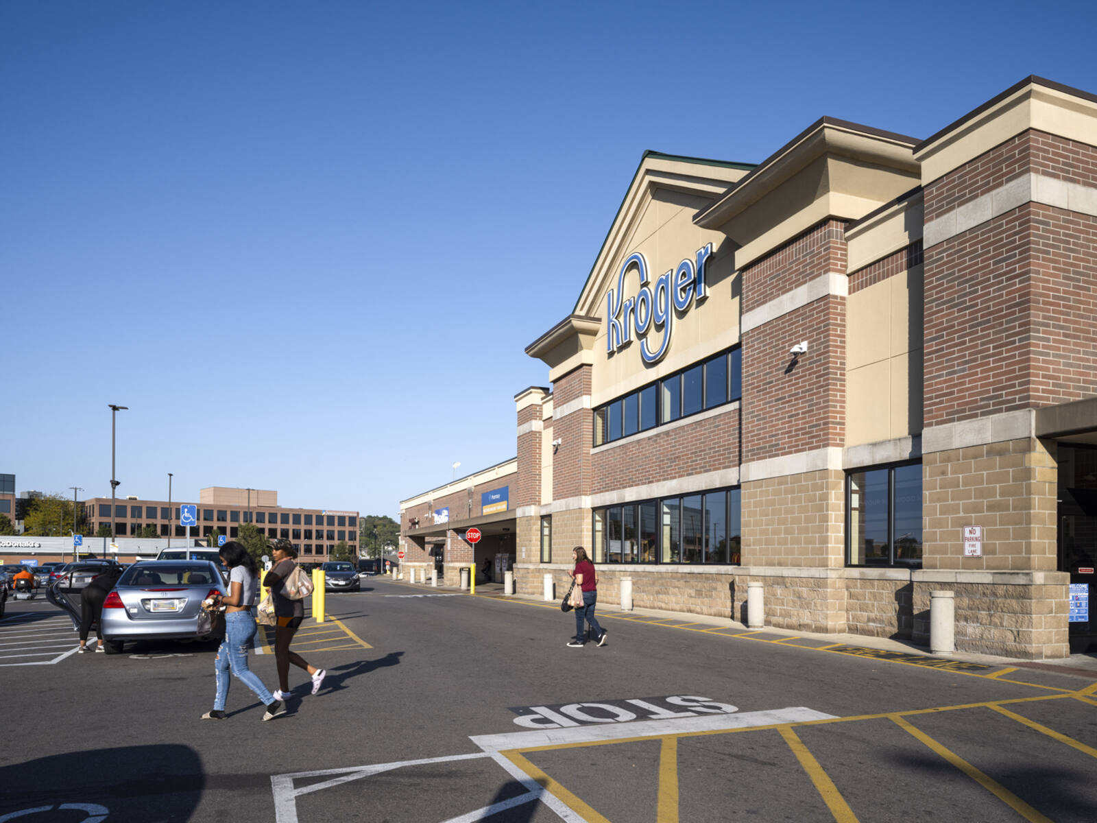 Customers enter and exit Kroger store into the parking lot.