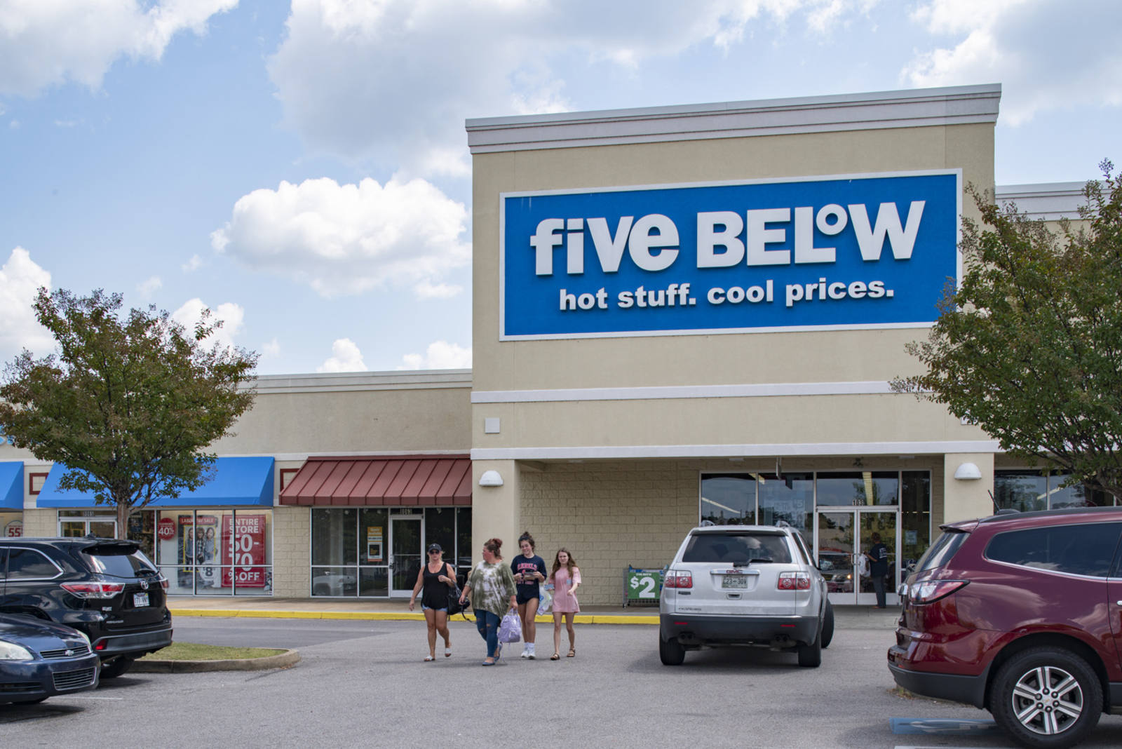 Five Below with women and grey jeep in front of store.