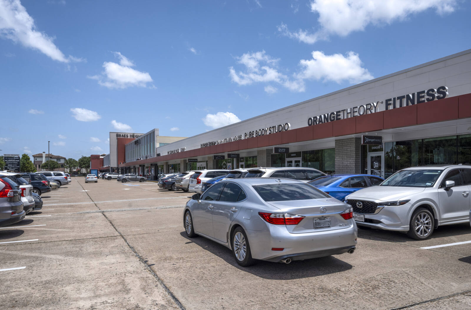Rows of parked cars in front of Orange Theory Fitness.