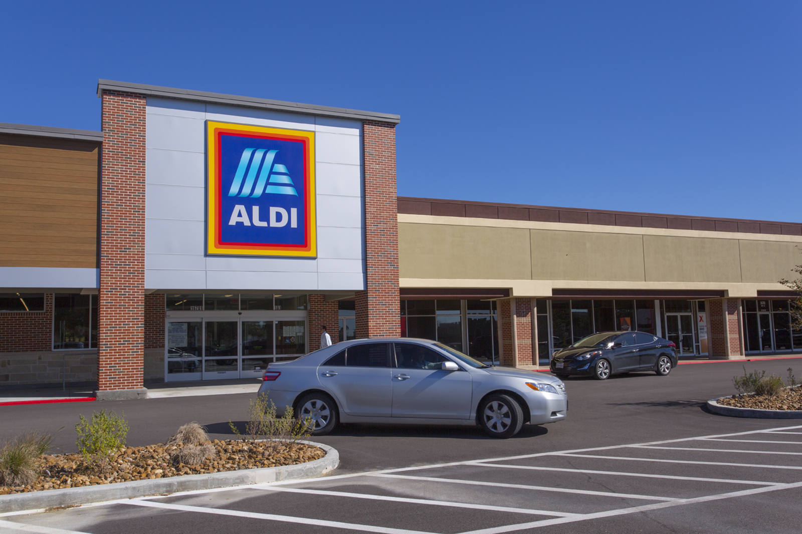 Grey car making a turn in front of Aldi supermarket in Houston, TX.
