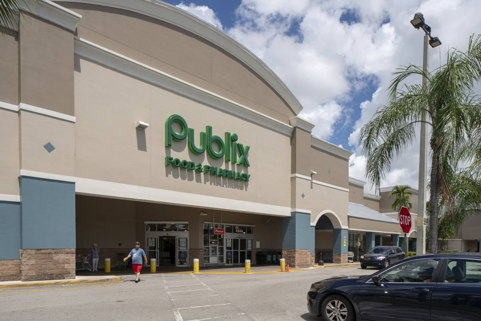 Blue cloudy sky and palm trees over Publix supermarket at Coconut Creek Plaza.