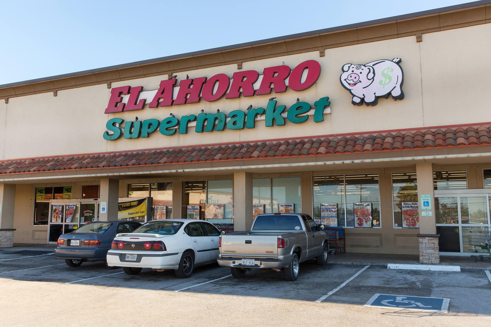 Cars line the front of El Ahorro Supermarket at shopping center in Bellaire, TX.