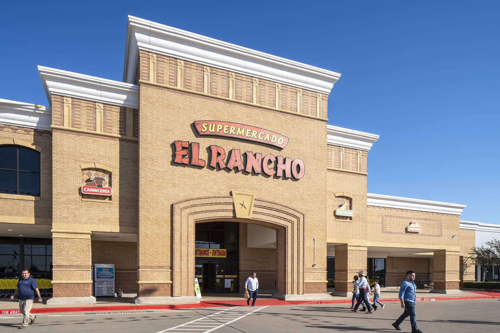 Pedestrians in front of El Rancho Supermercado in Houston, TX.