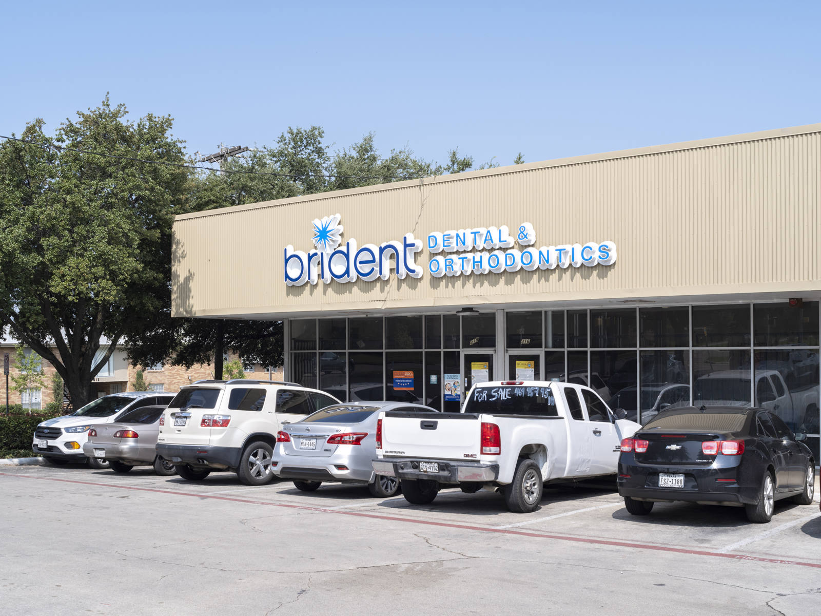 Brident orthodontics parking lot with tree in the back in Dallas, TX.