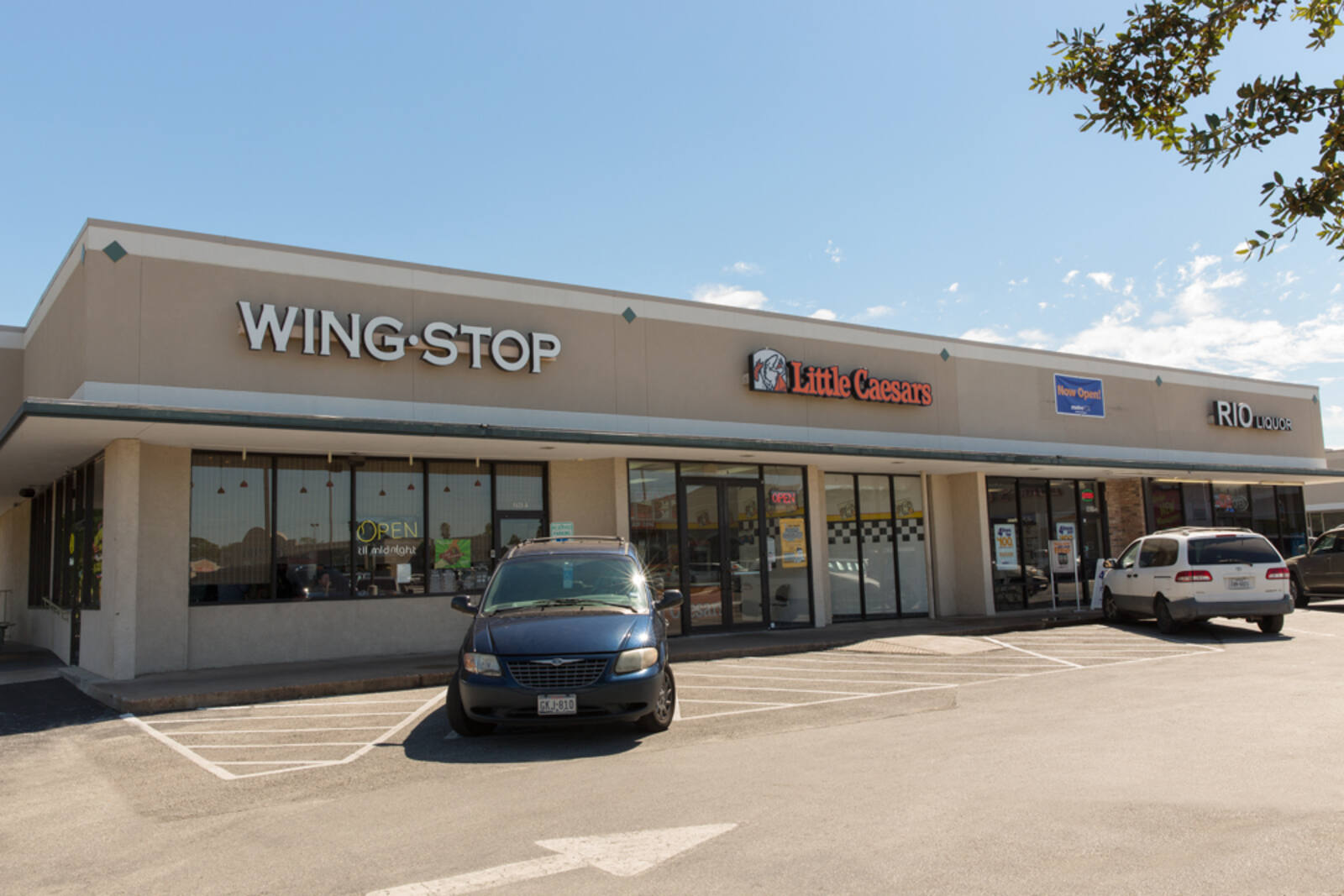 Minivans in the parking lot for Wingstop and Little Caesars in Houston, TX.
