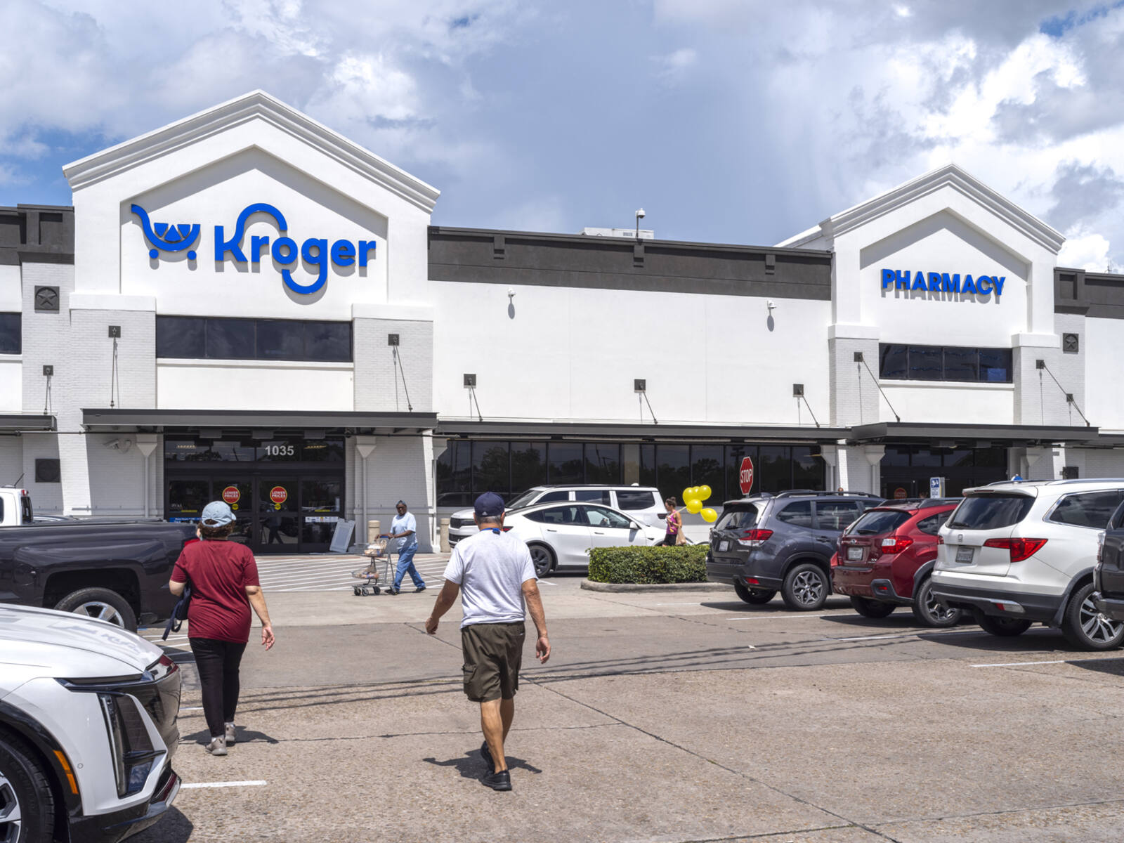 Patrons approach Kroger supermarket via an aisle in the parking lot.