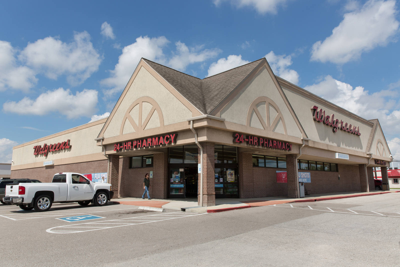 White pick up truck in front of corner lot entrance of Walgreens