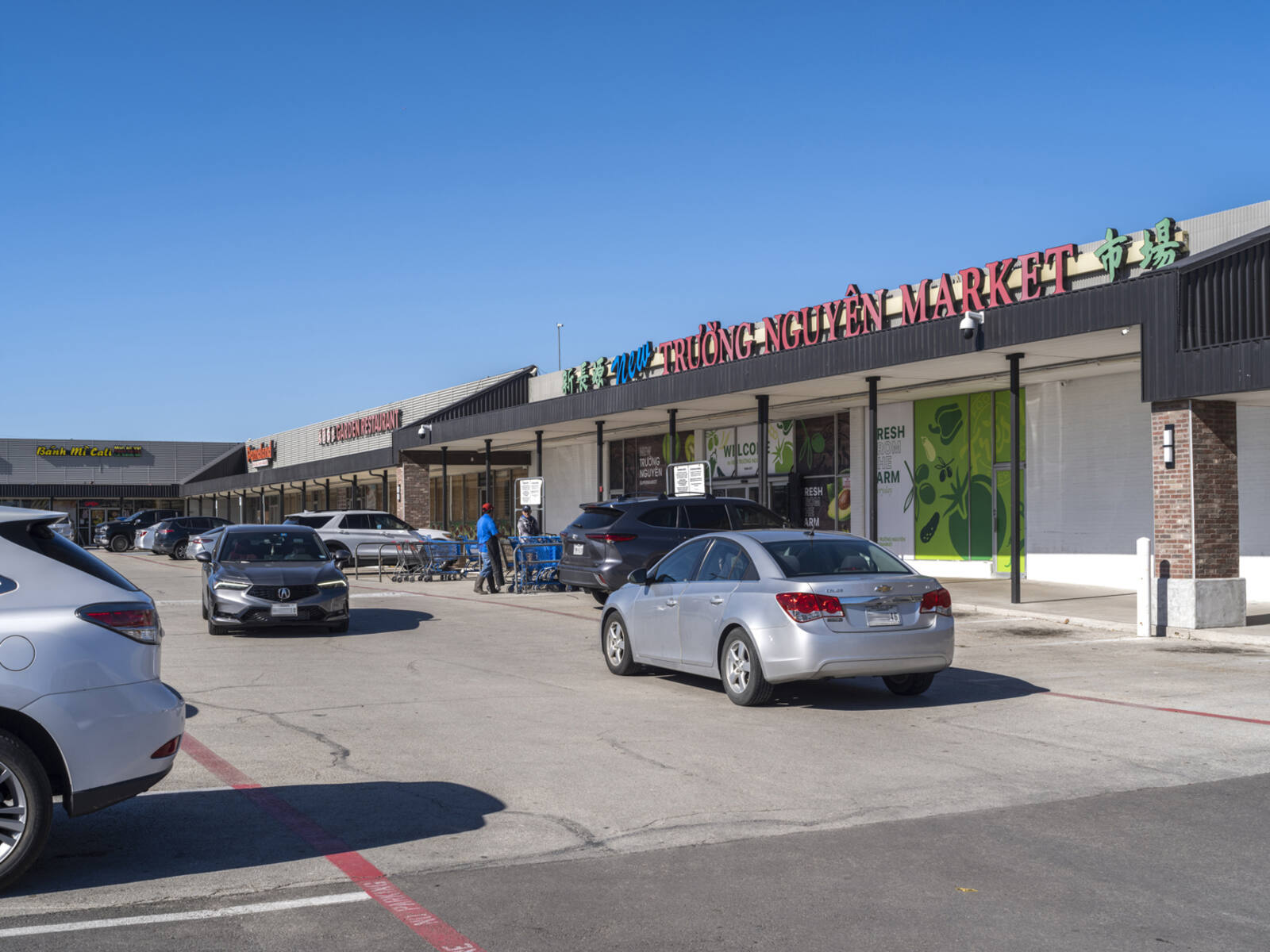 Cars passing Truong Nguyen Market on shopping center road.