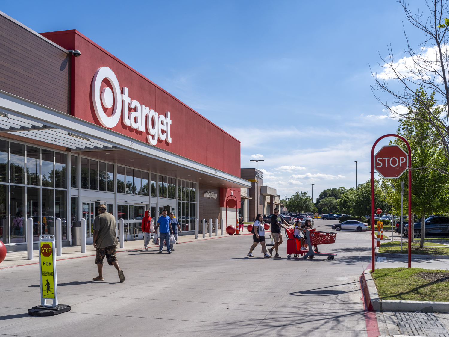 Shoppers in crosswalk for Target with parking lot in background.