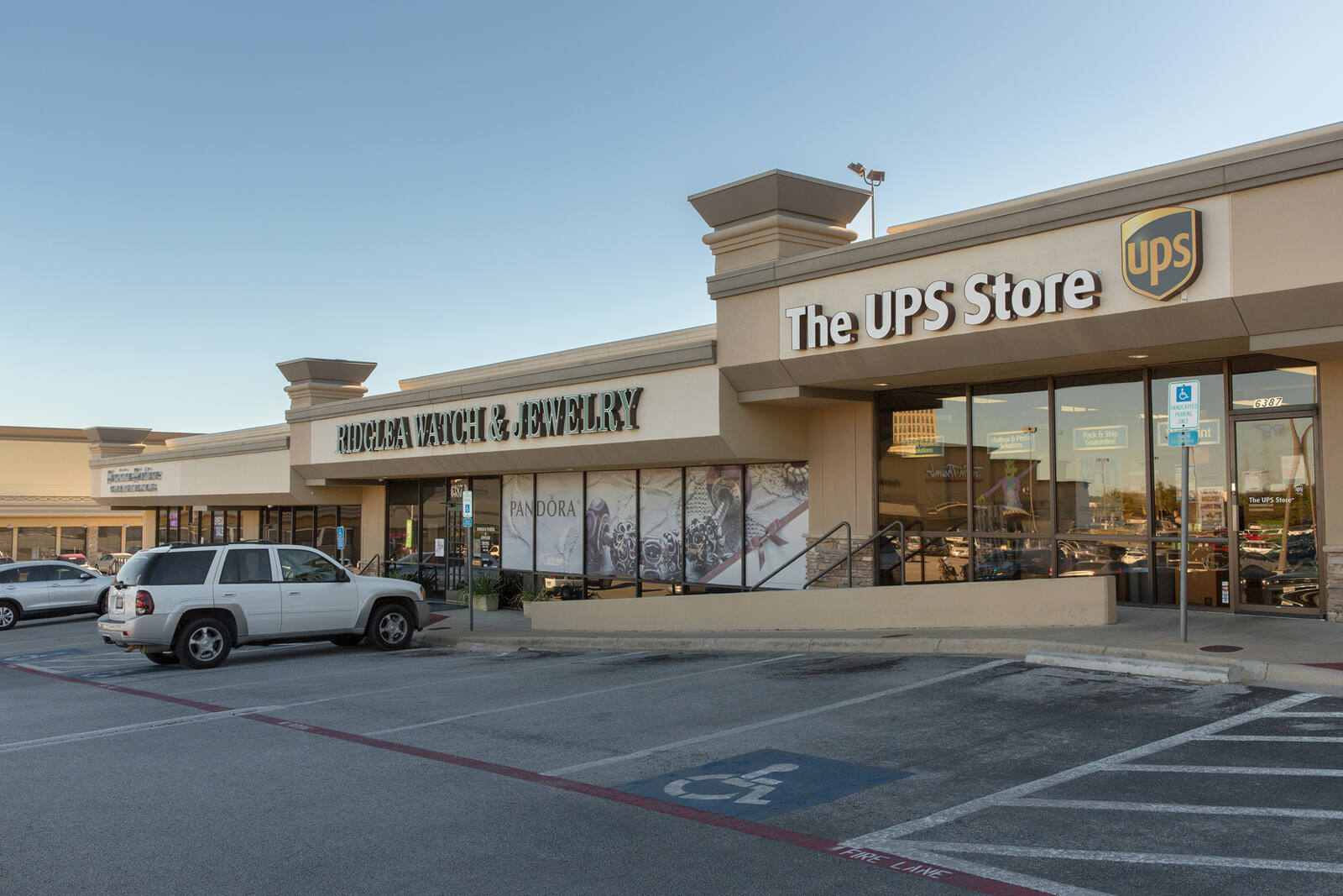 White SUV parked in front of The UPS Store